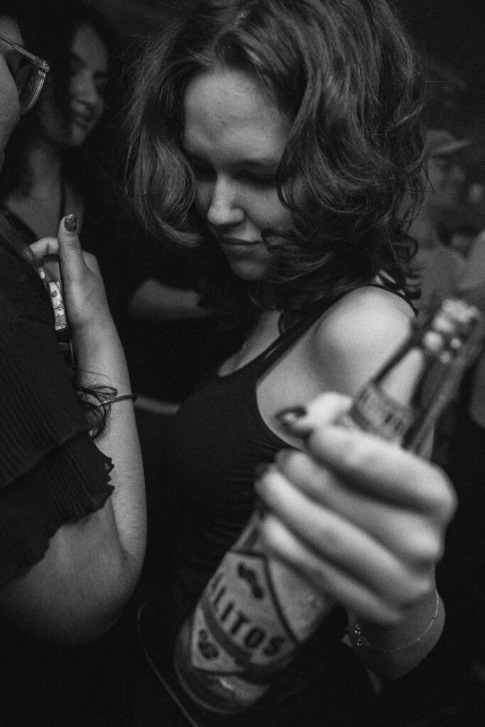 Eine Frau auf der Tanzfläche mit Flasche in der Hand